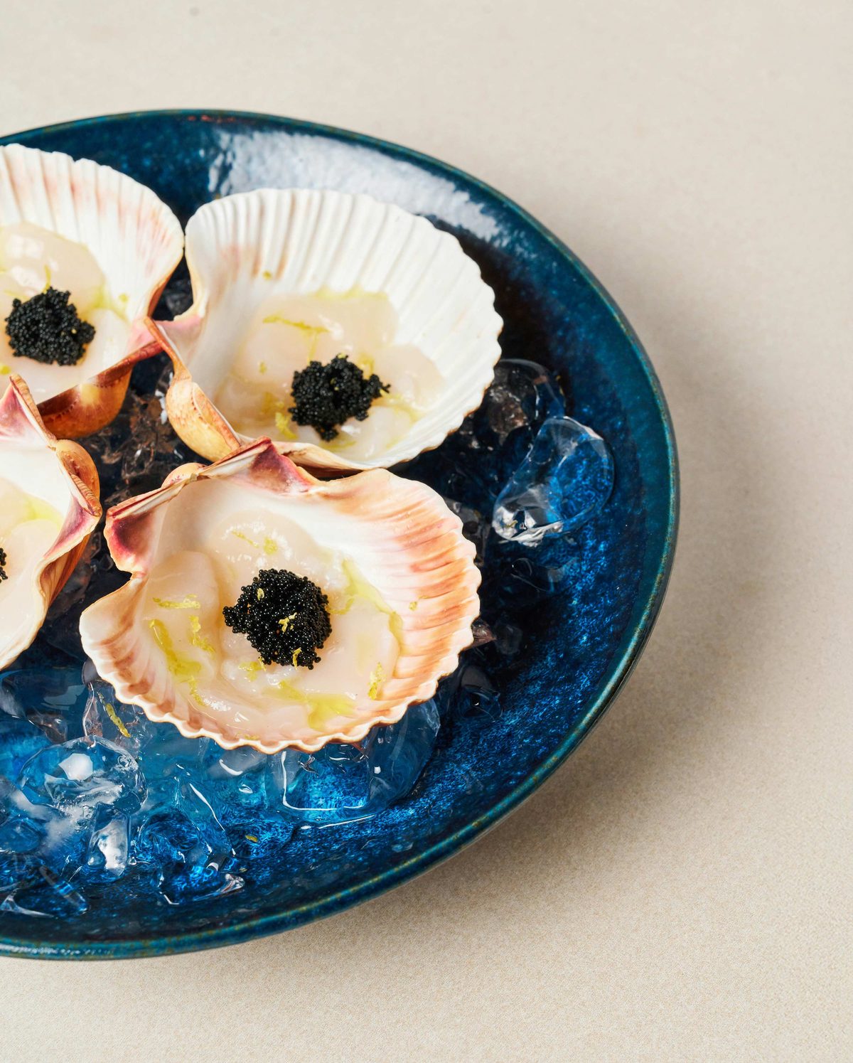 Scallops in the shell with caviar on ice